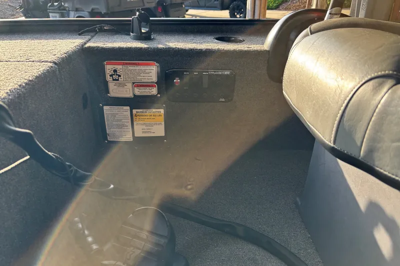 Slide: The Image of Interior of 2025 Tracker Panfish 17 boat showing seating and warning labels. - 13