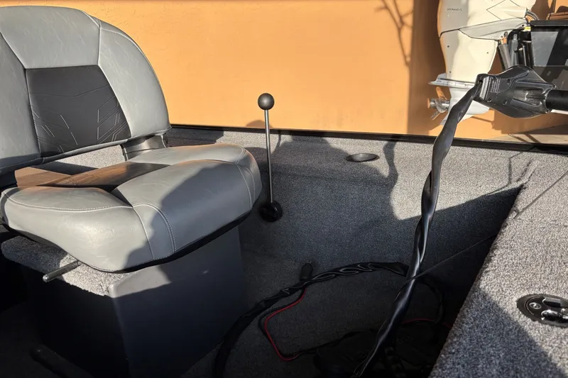 Slide: The Image of 2025 Tracker Panfish 17 boat interior with gray seat and control lever. - 9