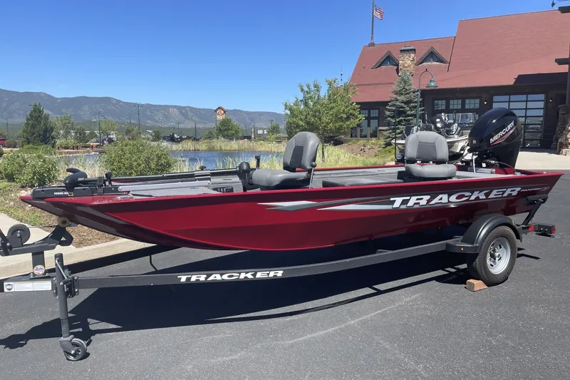 The Image of 2025 Tracker Panfish 17 boat in red, parked outdoors with scenic mountain backdrop. - 0