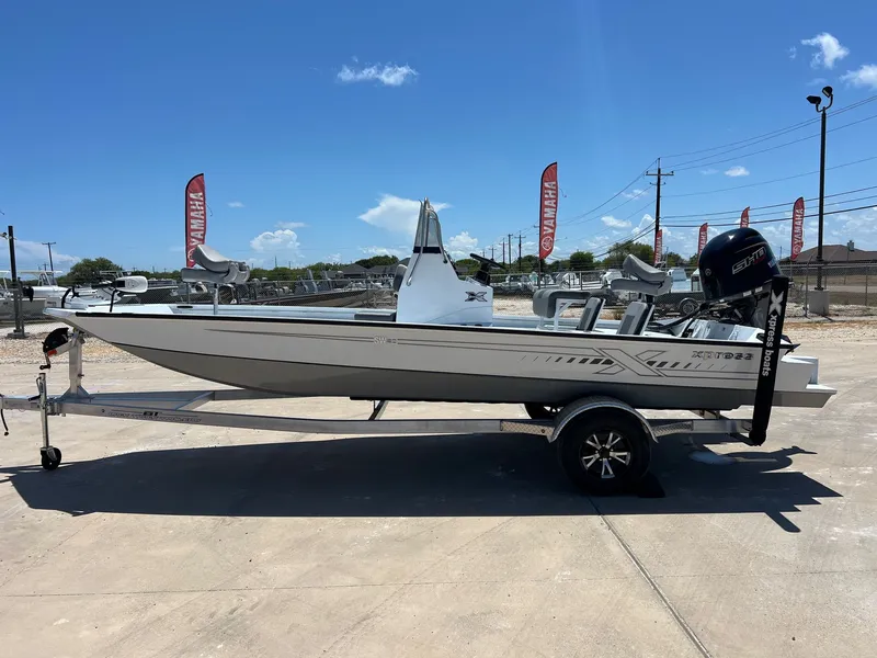 Slide: The Image of 2025 Xpress SW20B boat on trailer, outdoor display, Yamaha flags in background. - 37