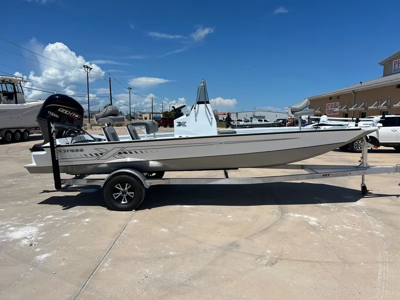 Slide: The Image of 2025 Xpress SW20B boat on trailer, Yamaha engine, parked outdoors under clear blue sky. - 43