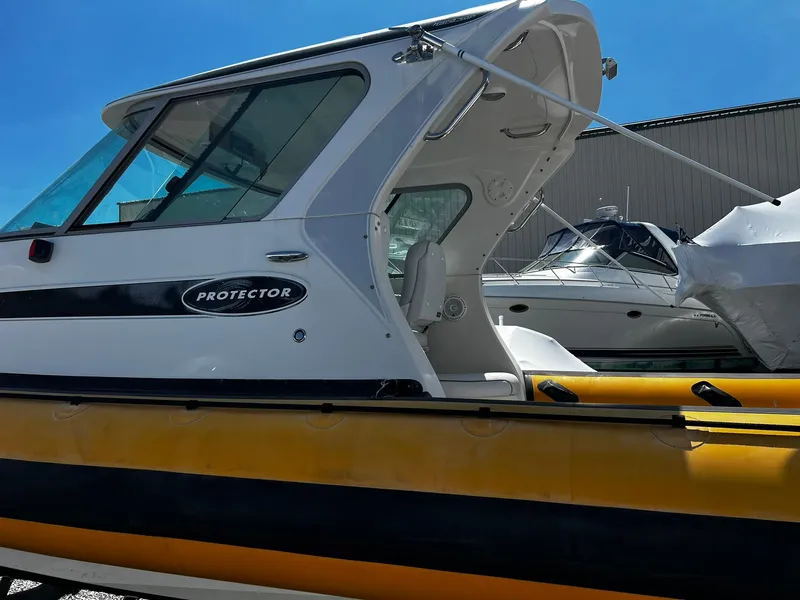 Slide: The Image of 2013 Protector Targa 30 boat with yellow hull, docked under clear blue sky. - 11
