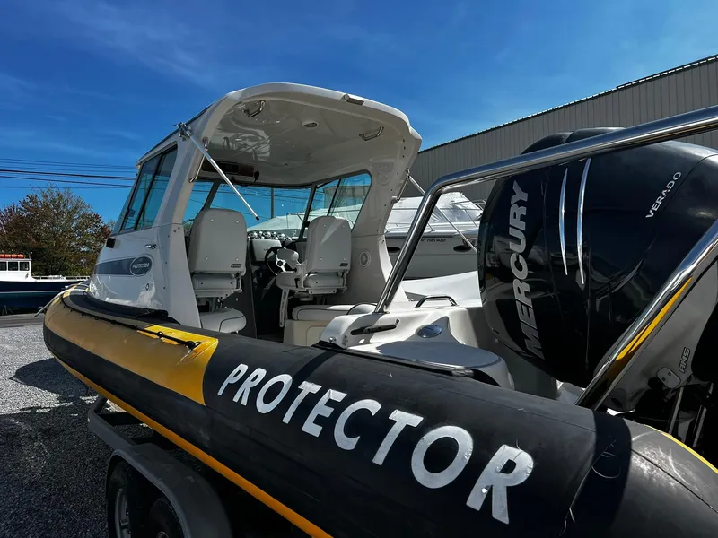 Slide: The Image of 2013 Protector Targa 30 boat with Mercury engine, docked outdoors under clear blue sky. - 13