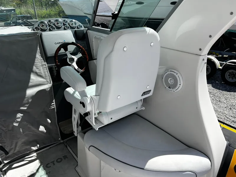 Slide: The Image of 2013 Protector Targa 30 boat interior with steering wheel and white captain's chair. - 16