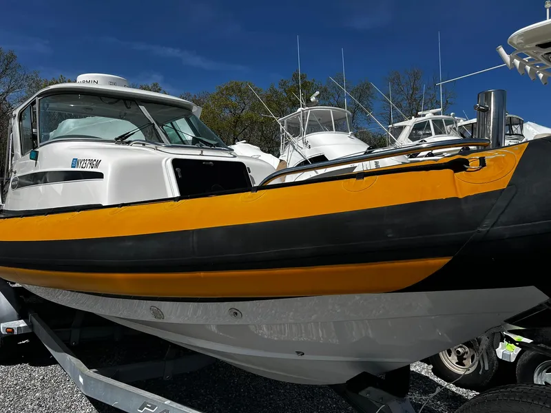 Slide: The Image of 2013 Protector Targa 30 boat with yellow and black hull on trailer. - 2
