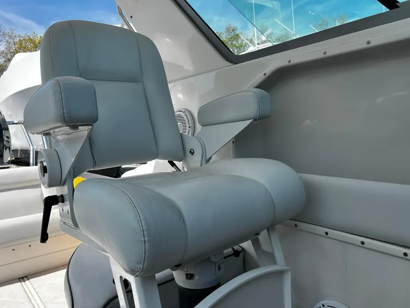 Slide: The Image of Captain's chair on 2013 Protector Targa 30 boat, featuring gray upholstery and armrests. - 32