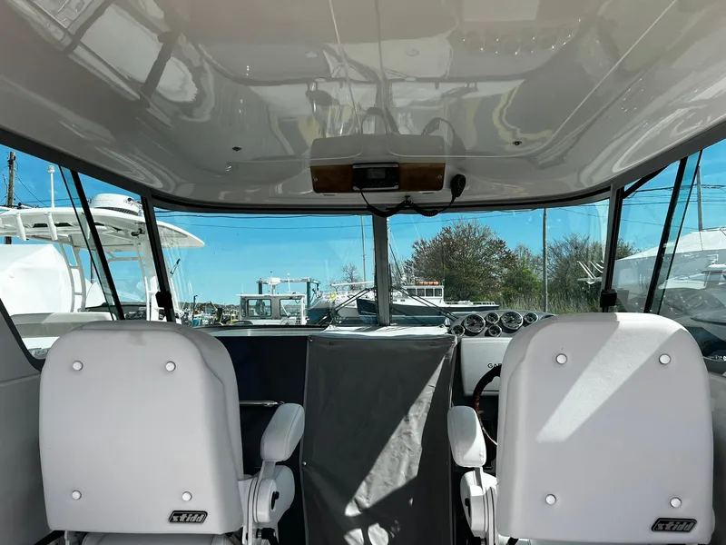Slide: The Image of Interior view of a 2013 Protector Targa 30 boat with two white seats. - 33