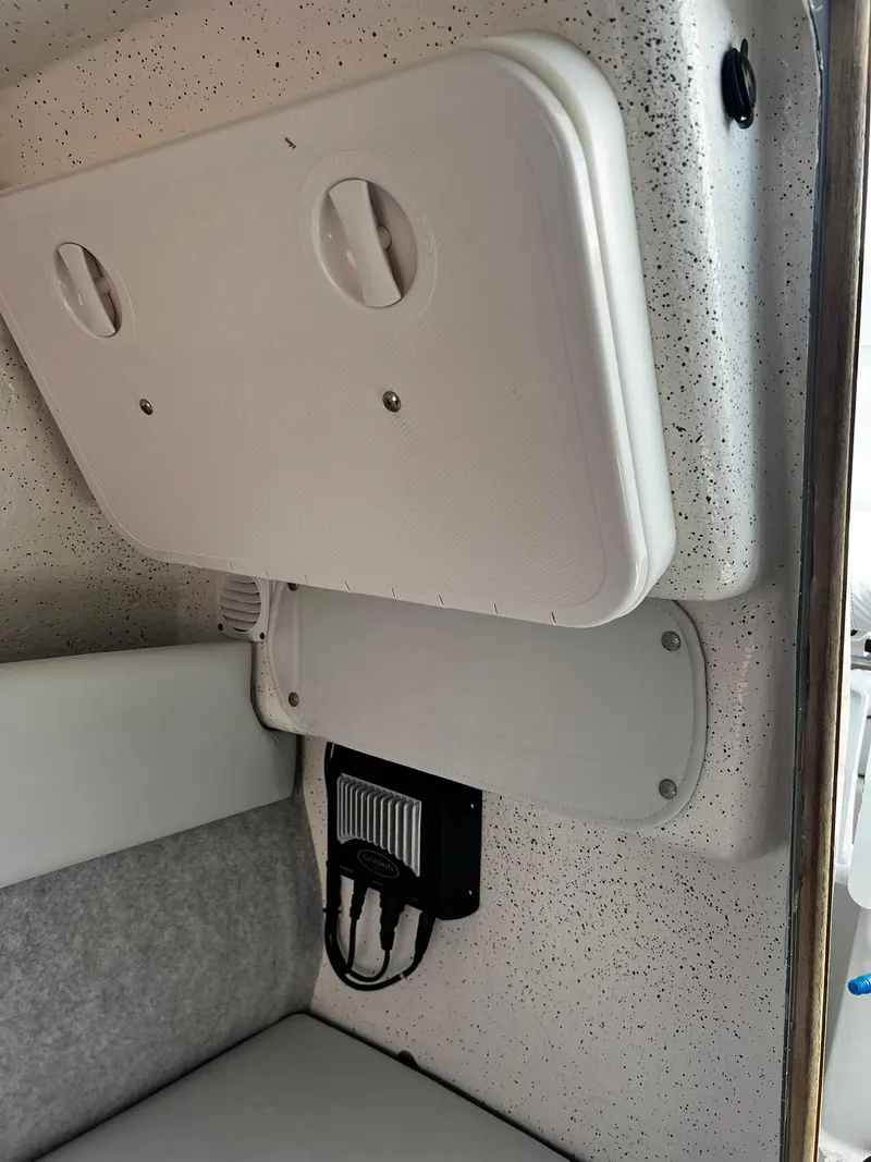 Slide: The Image of Interior of a 2013 Protector Targa 30 boat, featuring storage compartments and electrical panel. - 36