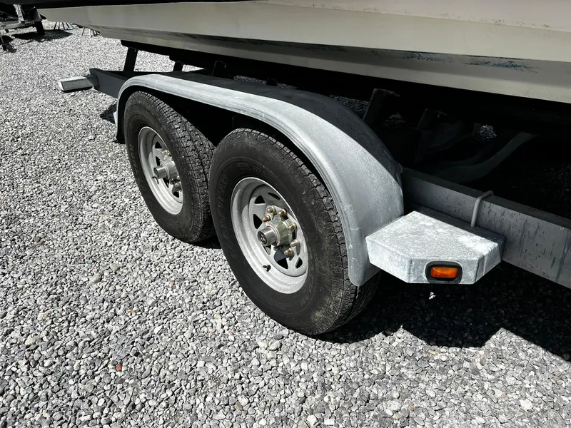 Slide: The Image of Trailer wheels of a 2013 Protector Targa 30 boat on gravel surface. - 43