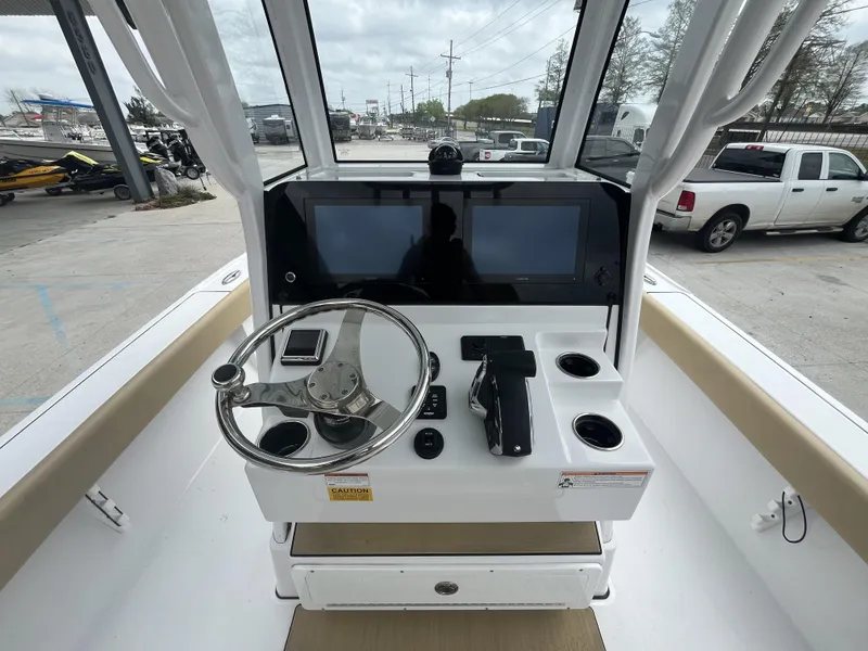 Slide: The Image of 2023 Sportsman Masters 267 boat dashboard with steering wheel and dual screens. - 12
