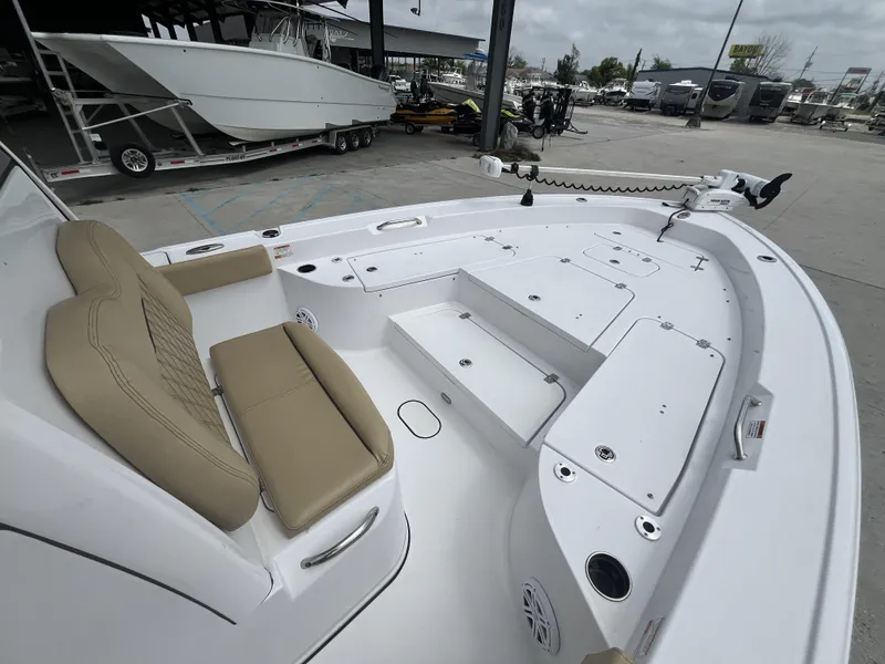 Slide: The Image of 2023 Sportsman Masters 267 boat interior with tan seating and storage compartments. - 13