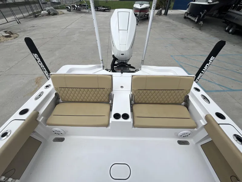 Slide: The Image of 2023 Sportsman Masters 267 boat interior with beige seating and outboard motor. - 16