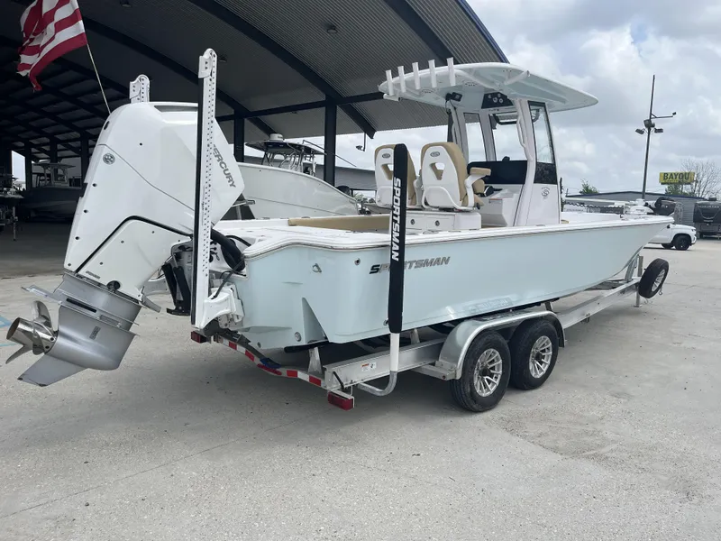 Slide: The Image of 2023 Sportsman Masters 267 boat on trailer, under covered area, with American flag. - 5