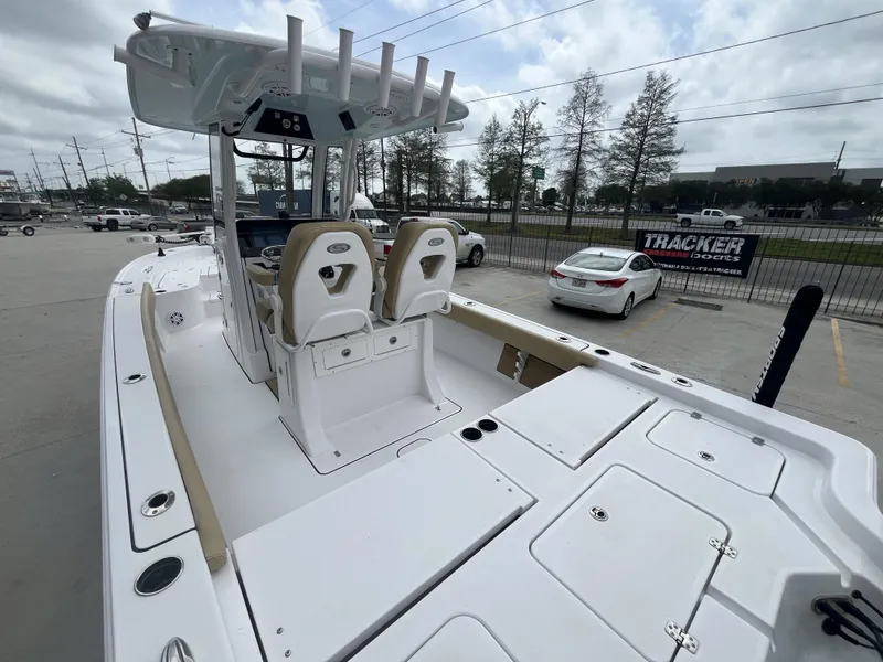 Slide: The Image of 2023 Sportsman Masters 267 boat with dual seats and spacious deck in a parking lot. - 6