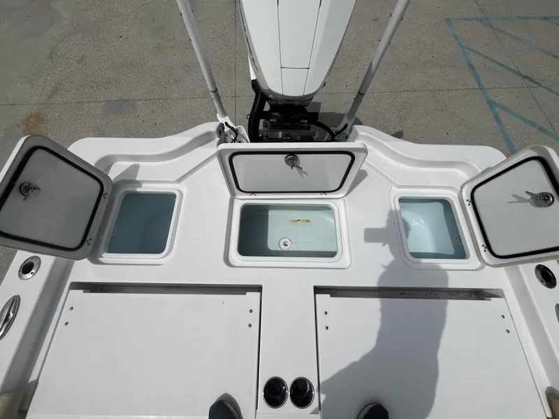 Slide: The Image of 2023 Sportsman Masters 267 boat deck with open storage compartments and motor. - 9