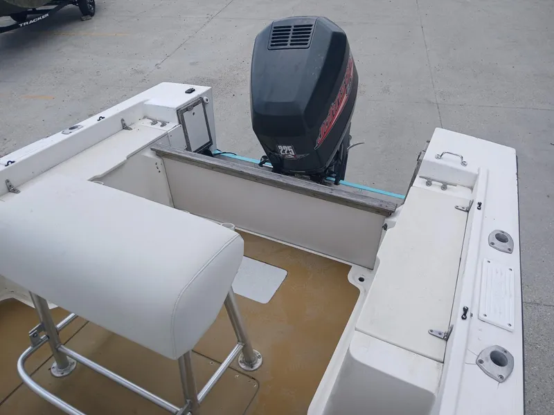Slide: The Image of 1980 Mako 213 boat interior with outboard motor and seating. - 10