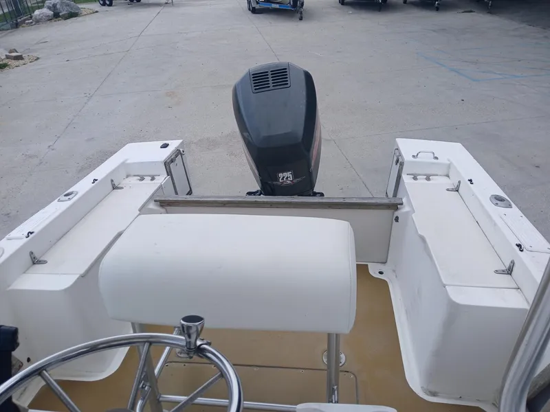 Slide: The Image of 1980 Mako 213 boat interior with steering wheel and outboard motor. - 12