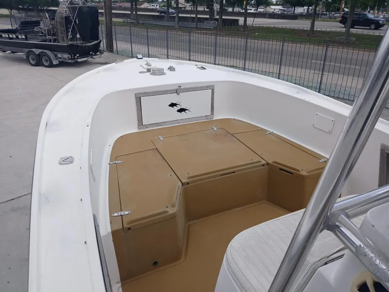 Slide: The Image of 1980 Mako 213 boat interior with tan deck and white seating. - 13