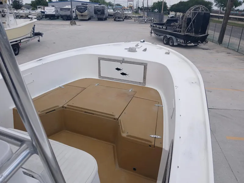 Slide: The Image of 1980 Mako 213 boat with spacious deck, parked in a marina. - 14