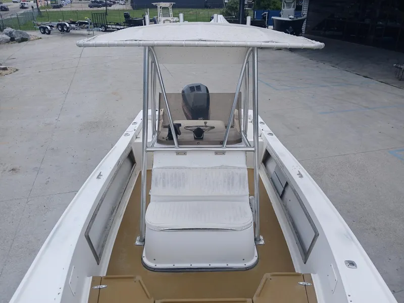 Slide: The Image of 1980 Mako 213 boat with T-top and center console, docked in a marina. - 15