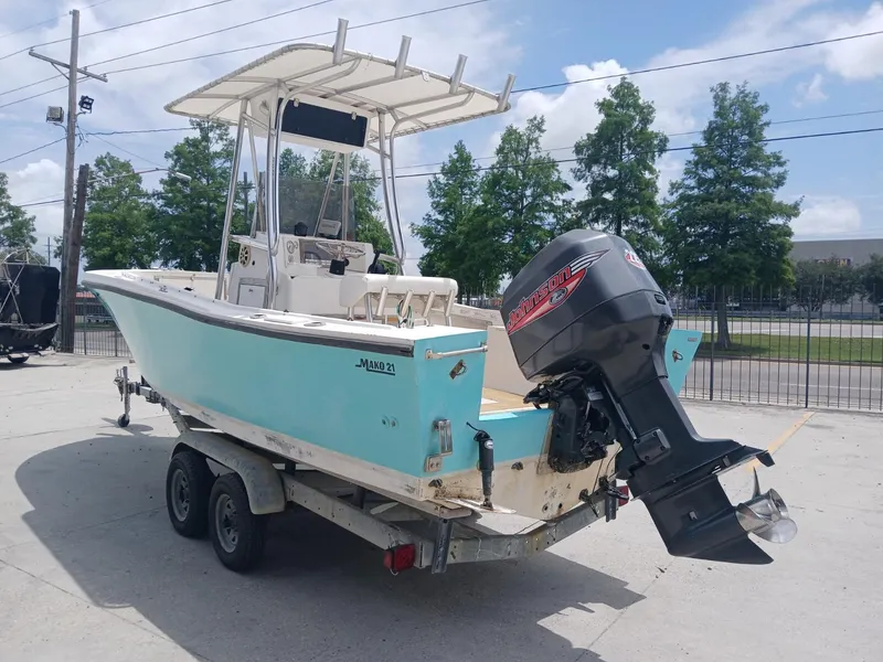 Slide: The Image of 1980 Mako 213 boat on trailer with outboard motor, parked outdoors. - 4