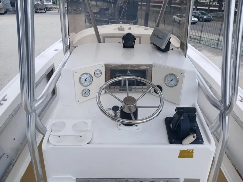 Slide: The Image of 1980 Mako 213 boat dashboard with steering wheel, gauges, and navigation equipment. - 9
