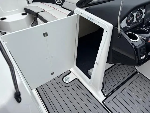 Slide: The Image of 2018 Yamaha Boats 212X interior with open storage compartment and sleek seating. - 18