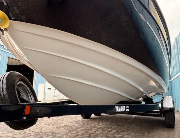 Slide: The Image of 2018 Yamaha Boats 212X on trailer, showcasing sleek hull design and sturdy construction. - 2