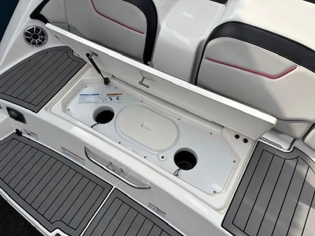 Slide: The Image of 2018 Yamaha Boats 212X storage compartment with open lid, showcasing interior design and seating. - 36