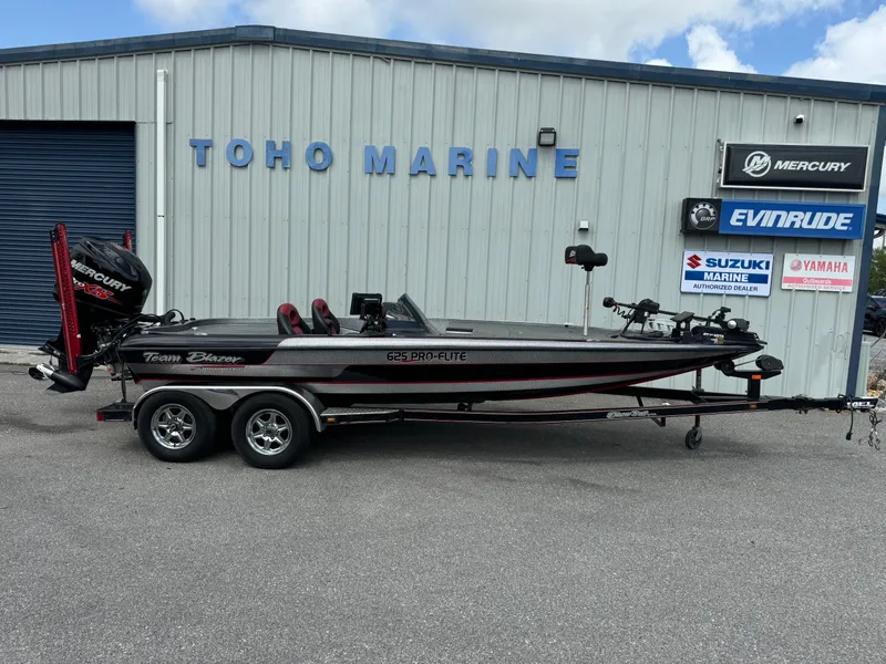 Slide: The Image of 2013 Blazer 625 boat at Toho Marine dealership, featuring dual-axle trailer and Mercury engine. - 1