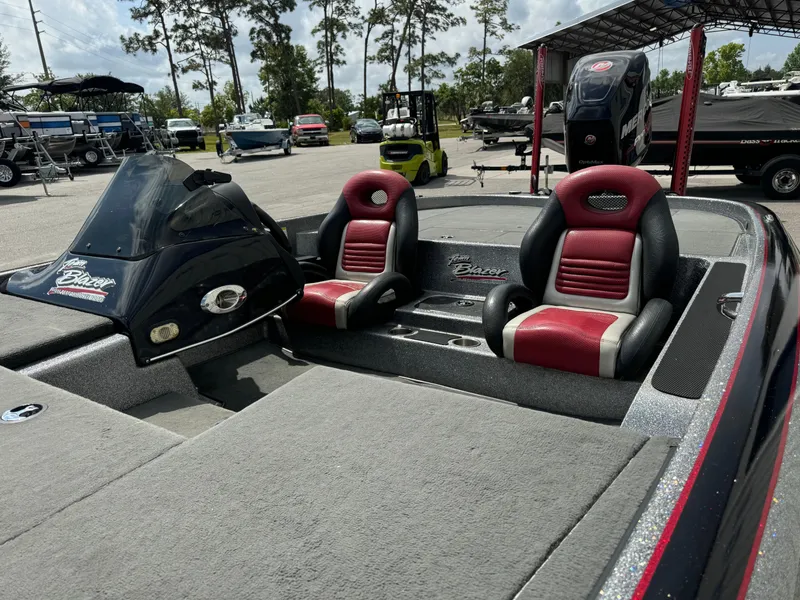 Slide: The Image of 2013 Blazer 625 boat with red and black seats, parked outdoors. - 10