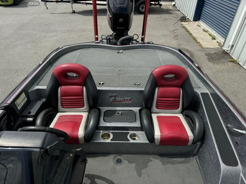 Slide: The Image of 2013 Blazer 625 boat interior with red and black seats, docked near storage units. - 11