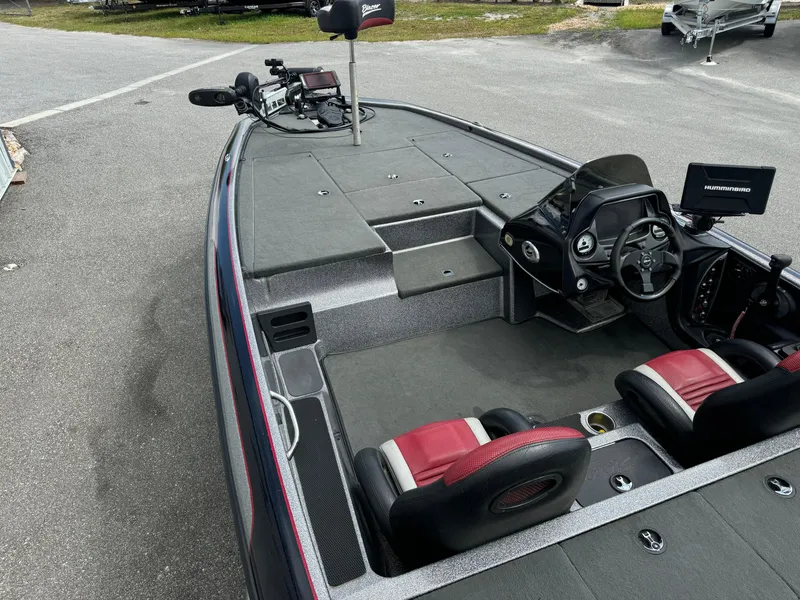 Slide: The Image of 2013 Blazer 625 boat interior with red seats and steering console. - 12