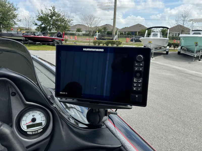 Slide: The Image of Humminbird fish finder on 2013 Blazer 625 boat dashboard, with gauge and parked boats in background. - 15
