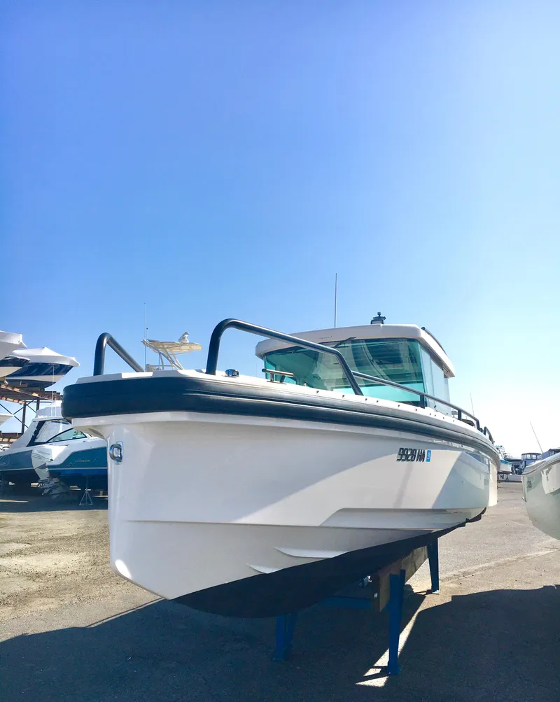 Slide: The Image of 2019 Axopar 28 CABIN boat on display under clear blue sky. - 1