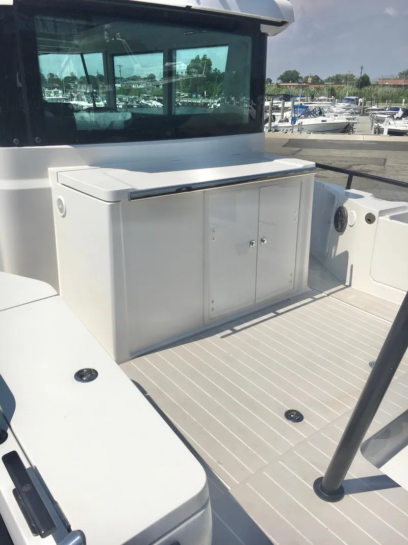 Slide: The Image of 2019 Axopar 28 CABIN boat deck with storage cabinet, docked at marina. - 10
