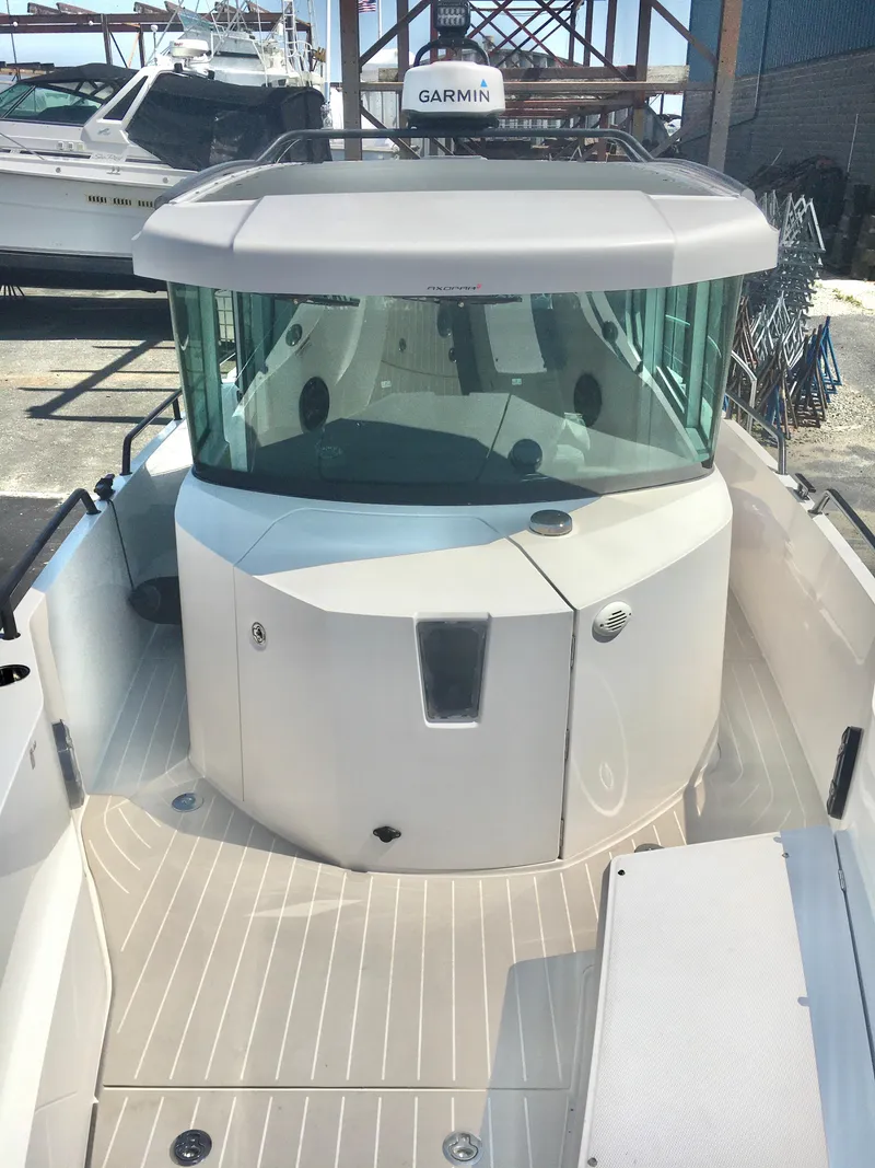 Slide: The Image of 2019 Axopar 28 CABIN boat with Garmin equipment, docked in a marina. - 17