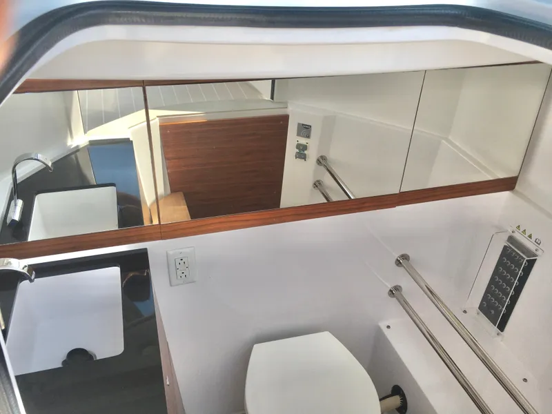 Slide: The Image of 2019 Axopar 28 CABIN bathroom with sink, mirror, and toilet. - 18