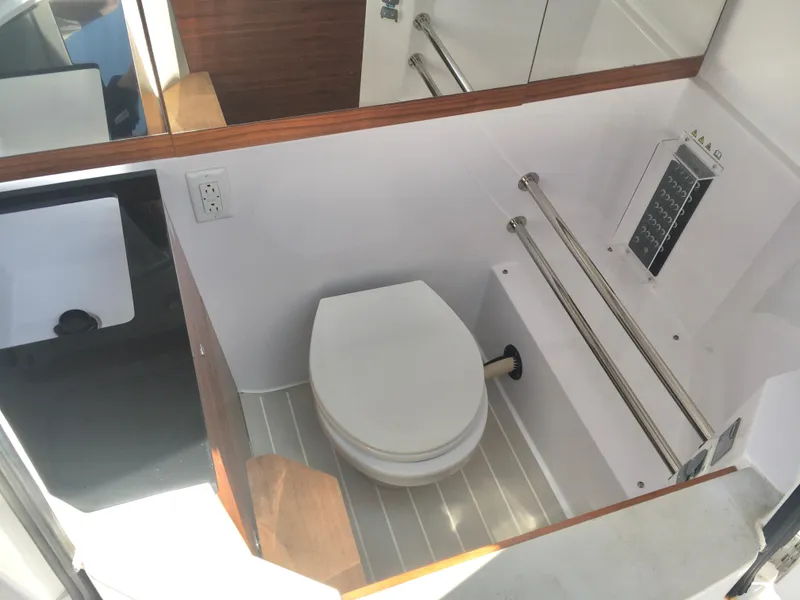 Slide: The Image of 2019 Axopar 28 CABIN bathroom with toilet, sink, and mirror. - 19