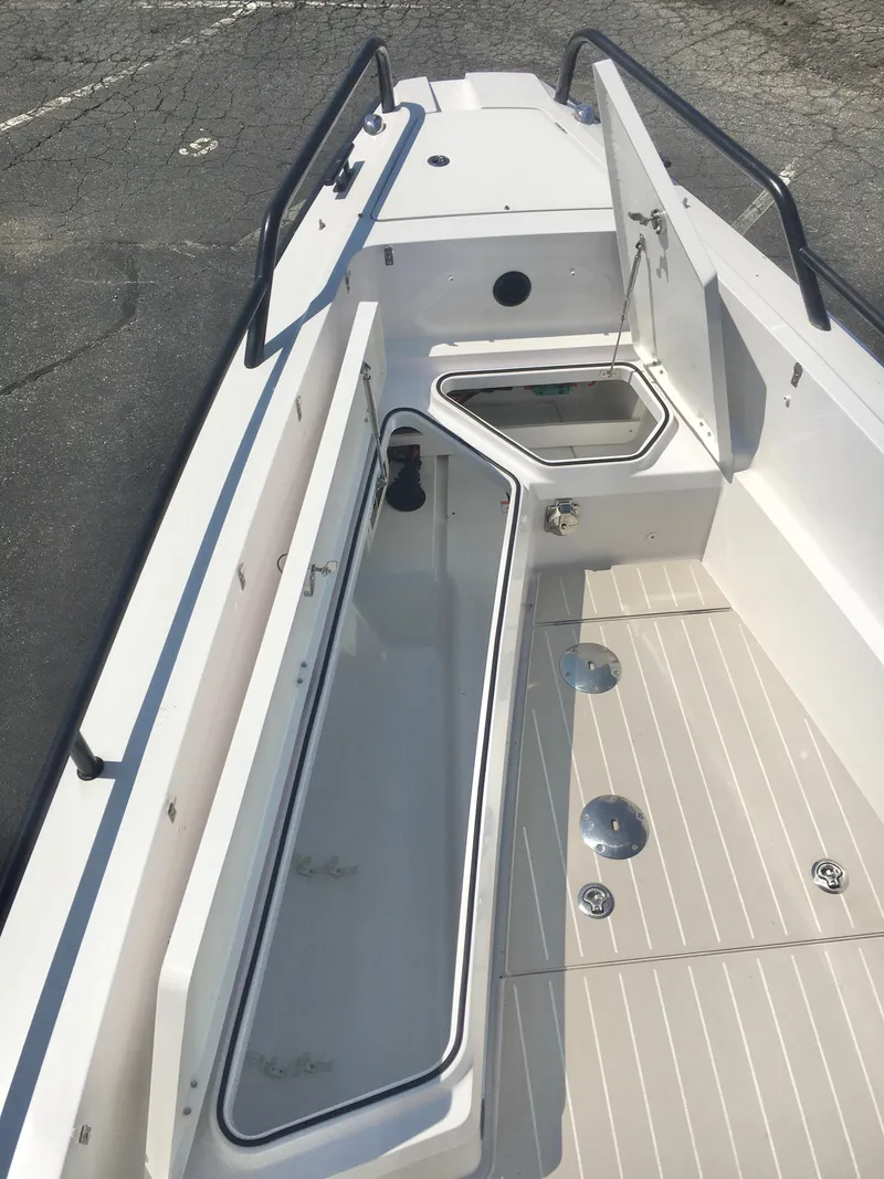 Slide: The Image of 2019 Axopar 28 CABIN boat deck with open storage compartments. - 21