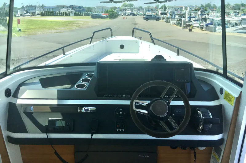 Slide: The Image of 2019 Axopar 28 CABIN boat dashboard with steering wheel and controls. - 25