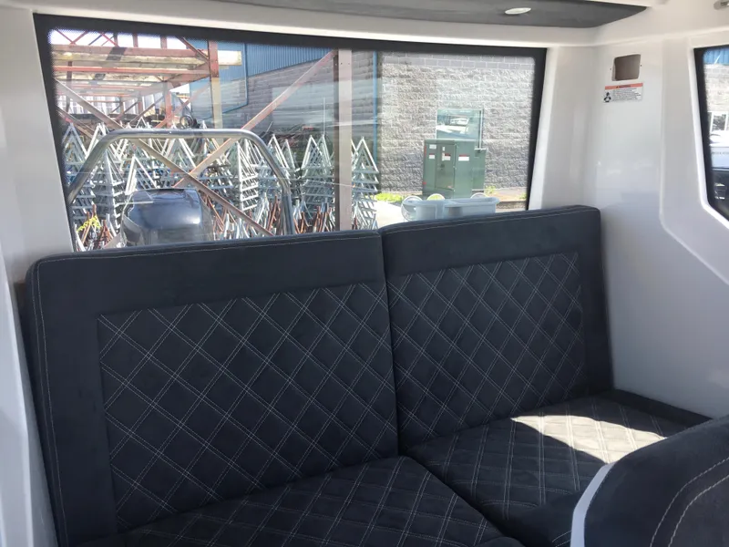 Slide: The Image of Interior of 2019 Axopar 28 CABIN with quilted seating and large window view. - 38