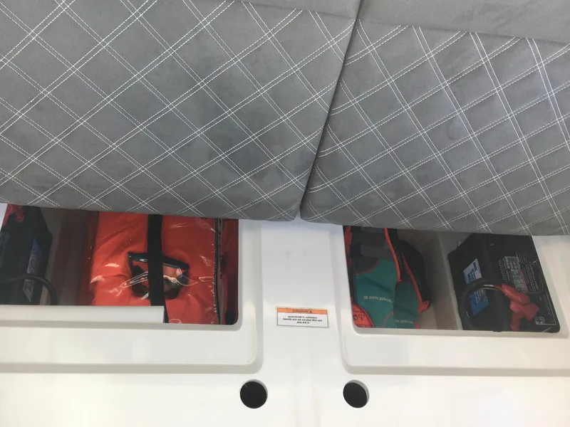 Slide: The Image of Storage compartments under seat in 2019 Axopar 28 CABIN boat, containing life jackets and equipment. - 39