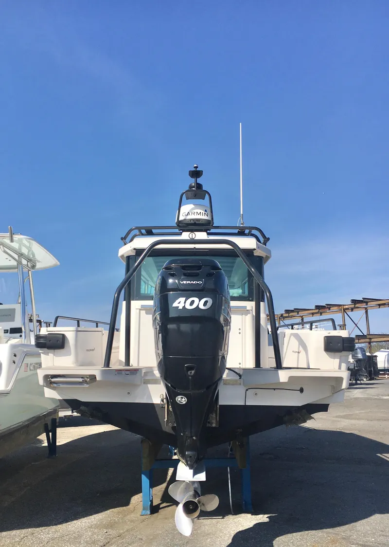 Slide: The Image of 2019 Axopar 28 CABIN boat with 400 HP engine, docked under clear blue sky. - 5