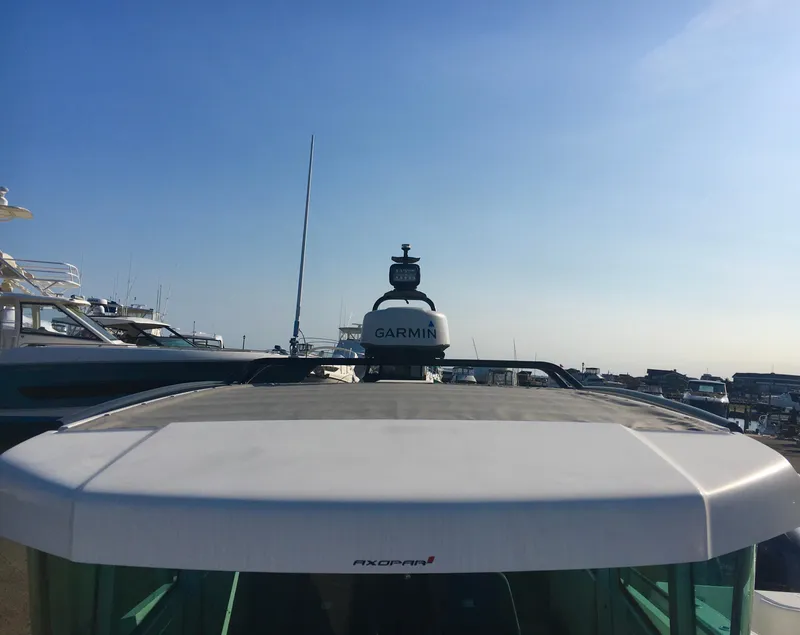 Slide: The Image of 2019 Axopar 28 CABIN boat with Garmin equipment, docked under clear blue sky. - 7