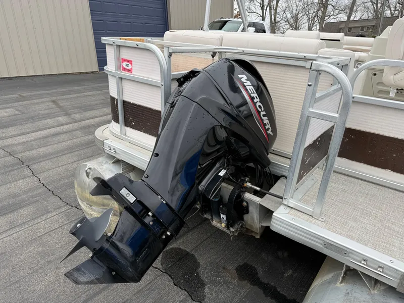 Slide: The Image of Pontoon boat with Mercury outboard motor, Premier Grand Majestic 1996 model, parked on pavement. - 5