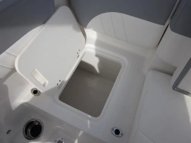 Slide: The Image of 2025 Chaparral 21 SSi boat storage compartment with open lid, showcasing interior space. - 19