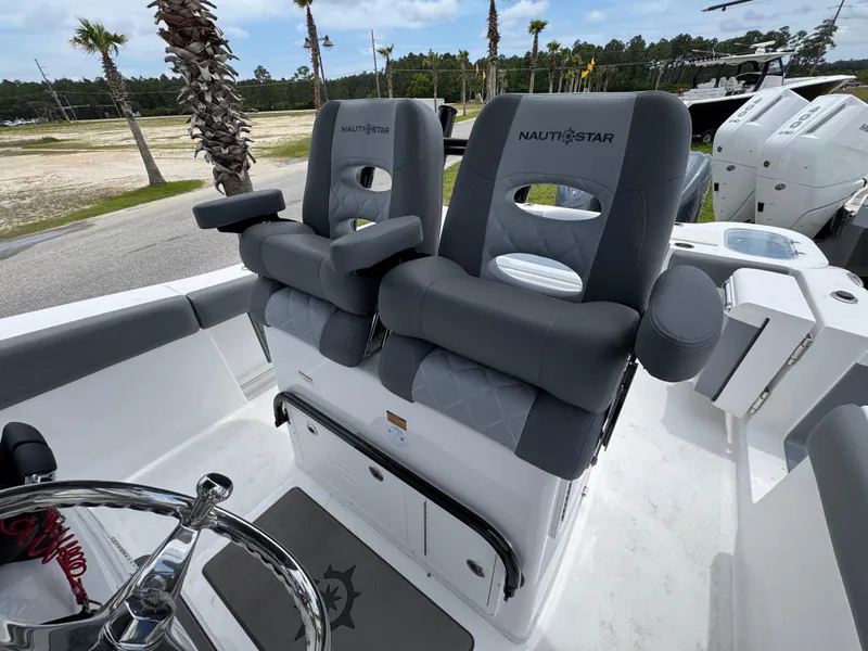 Slide: The Image of 2025 NauticStar 292 Legacy boat with dual gray captain's chairs and steering wheel. - 18