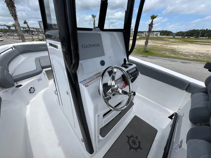 Slide: The Image of 2025 NauticStar 292 Legacy boat helm with Garmin navigation system, steering wheel, and seating. - 20