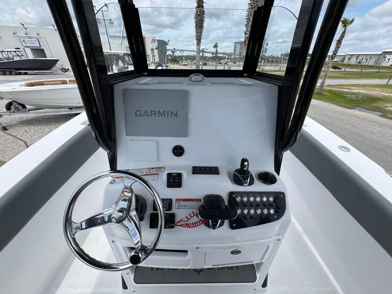 Slide: The Image of 2025 NauticStar 292 Legacy boat console with Garmin navigation system and steering wheel. - 21